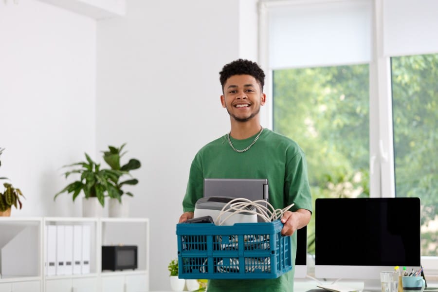A young man gathers old electronics to bring to DDS to safely recycle.