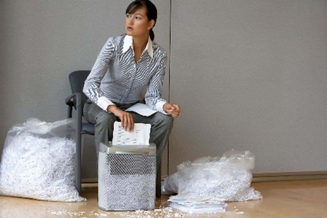 Office staff feed documents into a paper shredder as part of secure business document shredding in Lubbock, TX